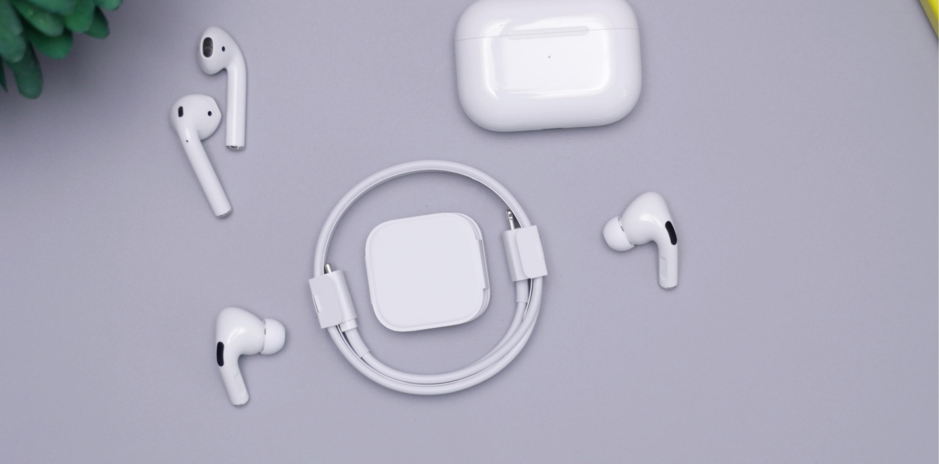 Different airpods and their accessories on a table.